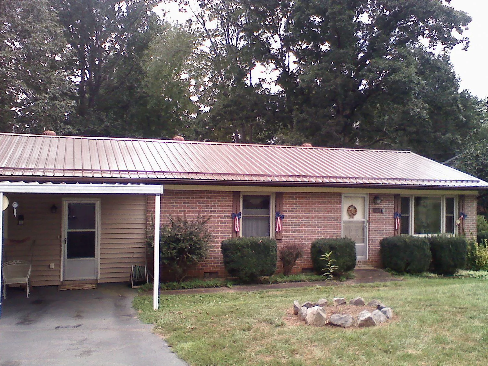 Bronze metal roof and carport on a brick ranch home — Roof Repair work by our crew in Chapin